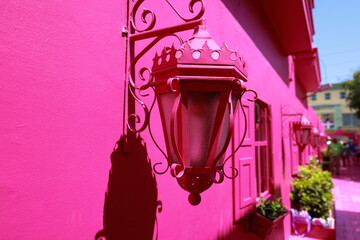 Pink facade with a window and lantern in Puerto Plata, Dominican Republic