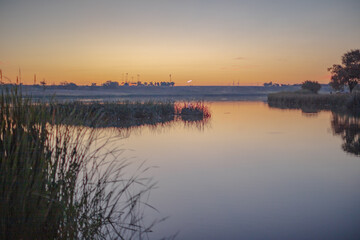 Fototapeta na wymiar Landscape photo at Dunbar Historical Lake Lubbock Texas of sunrise over water
