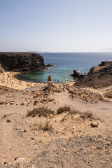 Natural white sandy beach landscape. Cove. Papagayo beach, Lanzarote. Beach and cliff. Turquoise ocean waters. Clear sky. Canary Islands, Spain