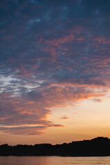 beautiful sunset with purple and pink sky, gloden hour over lake or river