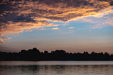 Naklejka premium beautiful sunset with purple and pink sky, gloden hour over lake or river