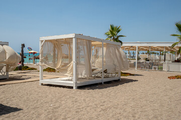 typical tropical atmosphere, beach holiday relax during sunny day in coastal resort with palm trees, baldaquin, deckchairs and ocean in the back, nobody © jan_S
