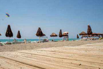 wooden plank path background with typical blurred umbrella and chairs atmosphere,  beach holiday relax during sunny day in tropical resort, nobody 