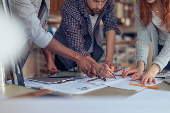 Young and diverse group of designers sketching and working on a project in a modern business office