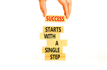 Success symbol. Concept words Success starts with a single step on wooden block. Beautiful white...