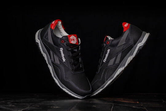 Kyiv, Ukraine - September 5, 2023: Reebok gray sneakers isolated on black background.