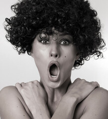 Beautiful girl with curly hair pointing to the side . Presenting your product. 
