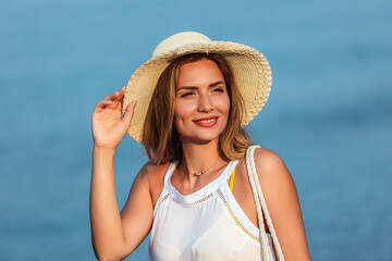 Happy young beautiful woman walking alone on the beach