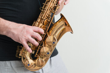 Hand of man playing on saxophone. Musician plays sax. Picture with copy space
