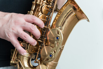 Hand of man playing on saxophone. Musician plays sax