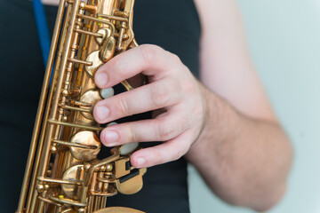 Hand of man playing on saxophone. Musician plays sax