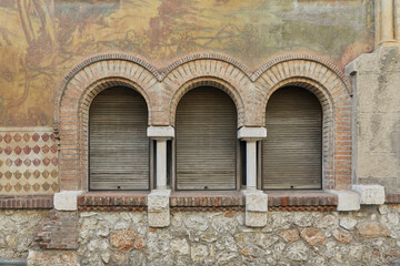 Fototapeta na wymiar Beautifully painted house facade with Romanesque windows.