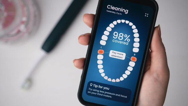 Smart electric toothbrush gives personal tips on dental care. Using a sonic electric toothbrush connected to a smartphone app.