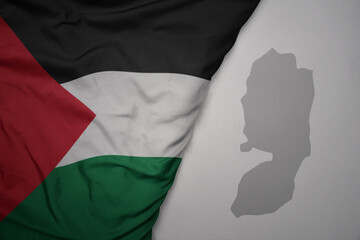 big waving national colorful flag and map of palestine on the gray background.