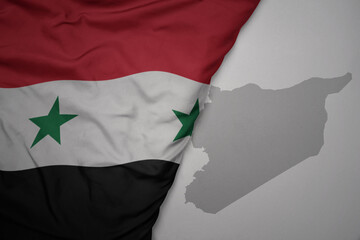 big waving national colorful flag and map of syria on the gray background.