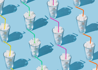 Creative pattern composition made of glasses full of sugar cubes with colorful drinking straws on...