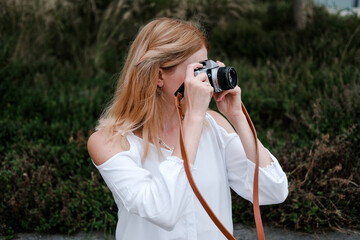 Frau mit Kamera, Fotografin unterwegs am fotografieren im Urlaub