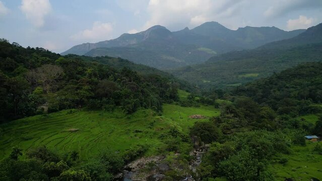 aerial footage as a drone descends from the sky to capture a mesmerizing waterfall in a remote mountainous village within the lush, green rainforest | Sri Lanka | Asia 