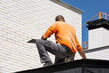 Obrero construyendo un tejado de pizarra.	