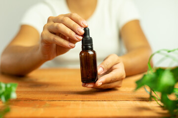 Glass jar with pipette, natural laboratory, biotechnology research tools, hands holding glass vials