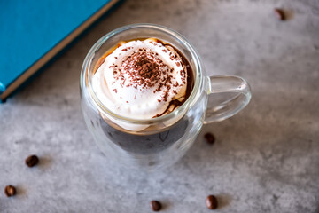 Top view for cup of coffee on grey background and book