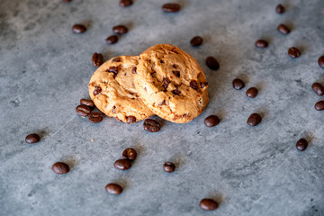 Two pieces of cookies with coffee beans on grey background