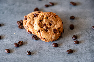 Two pieces of cookies with coffee beans on grey background