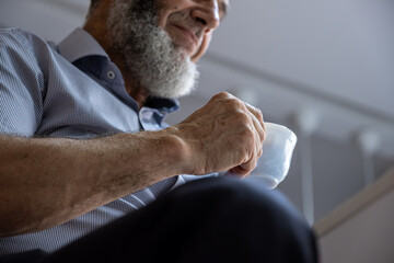 Old man drinking coffee with smile on his face