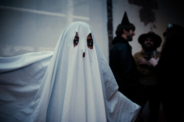 Adult in sheet ghost costume at Halloween party