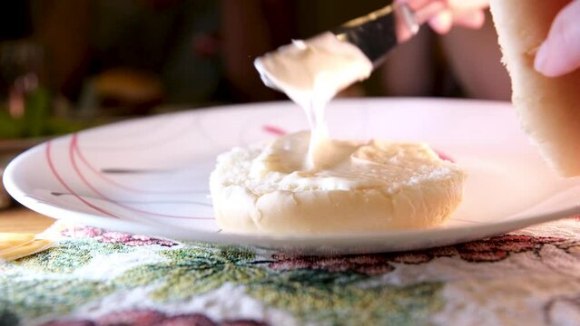 spread the bun with mayonnaise start preparing the burger light food fast food with knife spread the bread on the plate