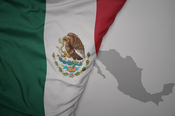 big waving national colorful flag and map of mexico on the gray background.