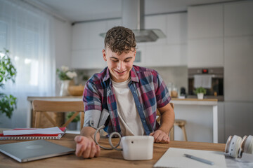 one teenager caucasian man measure check blood pressure at home alone