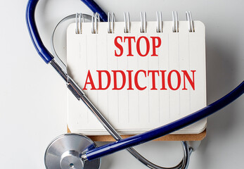 STOP ADDICTION word on notebook with medical equipment on background