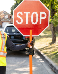 Security guard conducting traffic control with stop slow sign according to construction plan