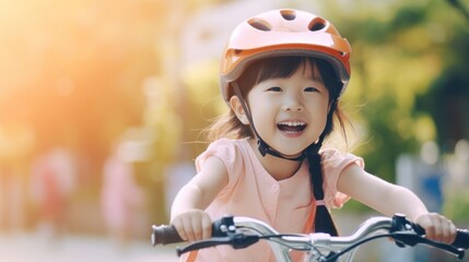 Cute little asian girl having fun by riding bicycle. Cute kid in safety helmet biking outdoors. natural light.