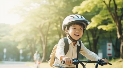 Fotobehang Cute little asian boy having fun by riding bicycle. Cute kid in safety helmet biking outdoors. natural light. © Pro Hi-Res