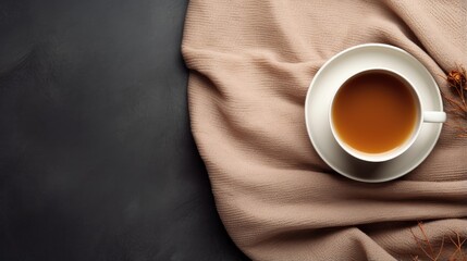 A cup of hot tea on a wool blanket seen from above, with empty space on the left as a background for words or promotional items. Perfect for winter themed designs, tea shops and relaxation designs.