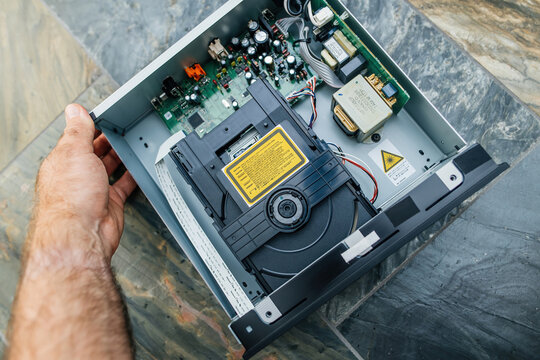 Munich, Germany - Sep 11, 2023: a male hand grasps the Onkyo C-755 CD-player with its top open, emphasizing its luxurious design of the hi-fi components
