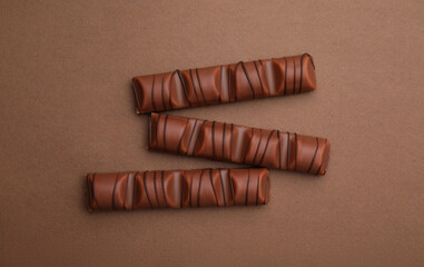 Tasty chocolate bars on brown background, flat lay