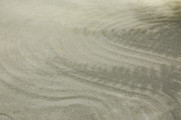 Beautiful lines and shadows of leaves on sand, closeup. Zen garden