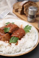 Delicious goulash served with rice on table, closeup