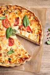 Tasty quiche with tomatoes, basil and cheese on wooden table, flat lay