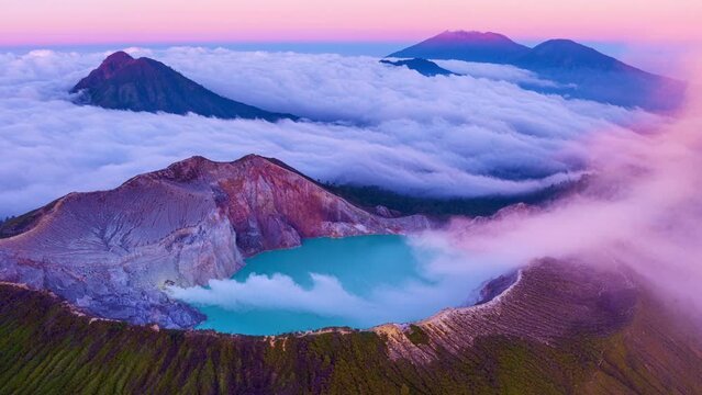Aerial view Drone Hyperlapse of fog at Kawah Ijen volcano with turquoise sulfur water lake at sunrise.Amazing nature landscape view at East Java,Indonesia.Beautiful light Natural landscape background