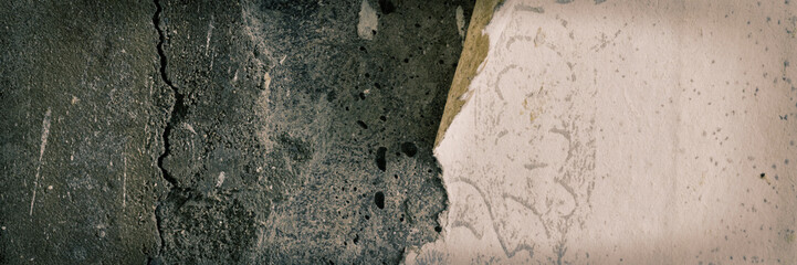 Torn old faded paper wallpaper with a retro pattern. Tattered scraps of paper on a concrete wall. Vintage texture for background and design. Closeup view with copy space.