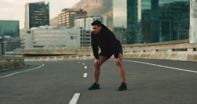 Breathing, road and fitness of man with rest from training, exercise and workout on city street. Marathon, runner and wellness of a tired athlete relax from running outdoor with sport and fatigue
