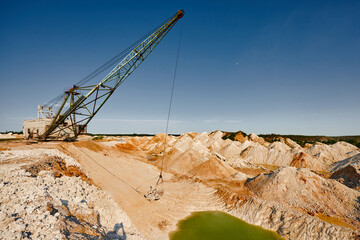 Fototapeta na wymiar Old dragline mines minerals in chalk quarry on sunny day