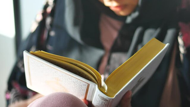 Muslim women's hand reading quran at night 