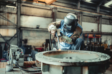 Industrial welder welding fabricated construction in factory, Welding process by Flux Core Welding,...