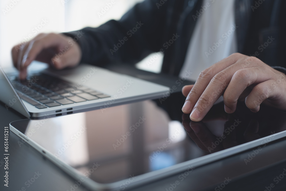 Aufkleber close up of man using digital tablet and working on laptop computer, browsing the internet, networki