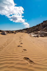 Fototapeta na wymiar Footprints on the sand going into the distance